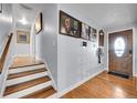 Inviting hallway with hardwood floors, staircase, and stylish decor leading to the front door at 55 S Flower St, Lakewood, CO 80226