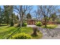 Charming brick ranch home with mature trees, lush landscaping, and circular driveway at 5471 S Sherman St, Littleton, CO 80121