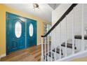 Bright entryway featuring a striking blue double door and staircase with white shiplap at 8397 Chase Dr, Arvada, CO 80003