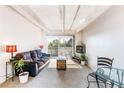 Cozy living room with wood beamed ceiling, a sofa and a trunk table, and a view to a balcony at 1441 N Humboldt St # 302, Denver, CO 80218