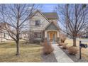 Charming two-story home with stone accents, inviting front porch, and manicured lawn at 1334 Carriage Dr, Longmont, CO 80501