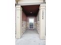 Covered front entry showcases stone pillars and a glass-paneled door with visible house number at 12564 Madison Way, Thornton, CO 80241