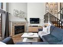Inviting living room with a cozy fireplace, modern decor, and staircase to the upper level at 10842 W Evans Ave # 34, Lakewood, CO 80227