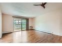 Bright living room with hardwood floors, a ceiling fan, and sliding glass doors to the patio at 9655 E Center Ave # 11D, Denver, CO 80247
