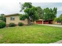 Charming brick home features a well-manicured lawn, mature trees, and a two-car garage at 1705 Lewis St, Lakewood, CO 80215