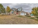 Inviting two-story home with brick, blue siding, and a three-car garage on a spacious lot at 18715 Wagon Trl, Mead, CO 80542