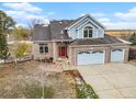 Attractive two-story brick-and-blue home with a three-car garage and well-maintained landscaping at 18715 Wagon Trl, Mead, CO 80542