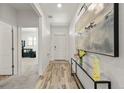 Bright entryway featuring modern decor, wood-look floors, and fresh white walls at 6912 Poudre St, Frederick, CO 80530