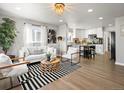 Bright living room featuring modern furniture, wood floors, a stylish rug, and an open concept flowing into the kitchen at 1385 S Newton St, Denver, CO 80219