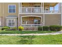Exterior facade of the condo with stone accents, a private porch, and manicured landscaping at 6013 Castlegate W Dr # D14, Castle Rock, CO 80108