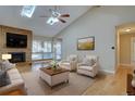 Inviting living room featuring a fireplace, hardwood floors, high ceilings with skylights, and ample natural light at 6495 E Happy Canyon Rd # 22, Denver, CO 80237
