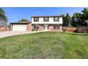 Landscaped, two-story home with a lawn, driveway, and two-car garage at 9451 W Hialeah Pl, Littleton, CO 80123
