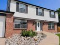 Close up of a two-story home showing a white front door and rock landscaping at 9451 W Hialeah Pl, Littleton, CO 80123
