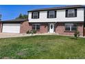 Two-story home on a manicured lawn, with a driveway leading to a two-car garage at 9451 W Hialeah Pl, Littleton, CO 80123