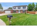 Traditional two-story home with a large front lawn and a mailbox near the street at 9451 W Hialeah Pl, Littleton, CO 80123