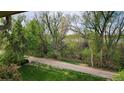 Balcony view featuring a paved path with lush green foliage and mature trees at 655 S Alton Way # 8D, Denver, CO 80247