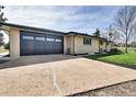 View of a large garage and wide driveway on a well maintained property at 16816 E Costilla Ave, Foxfield, CO 80016
