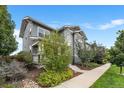 Gray siding two-story home with landscaping and walkway at 5524 Uinta St, Denver, CO 80238