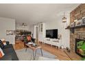 Spacious living room with hardwood floors, stone fireplace, and built-in shelving at 8555 Fairmount Dr # G208, Denver, CO 80247