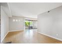 Bright living room with hardwood floors, access to patio through sliding glass doors and neutral walls at 6490 S Dayton St # L02, Englewood, CO 80111