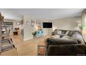 Spacious living room featuring a comfortable sectional sofa, hardwood floors, and natural light from the windows at 12286 W Tennessee Ave, Lakewood, CO 80228