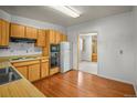 Functional kitchen features wood cabinets, tile backsplash, and hardwood flooring at 245 S 13Th Ave, Brighton, CO 80601