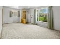 Bright living room with large windows, neutral carpeting, and a decorative shelving unit at 245 S 13Th Ave, Brighton, CO 80601