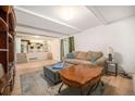 Bright living room with wood floors, comfortable seating, and an open layout leading to the kitchen at 12289 W Atlantic Ave, Lakewood, CO 80228