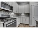 Modern kitchen with white cabinets and granite countertops at 8668 E 54Th Pl, Denver, CO 80238