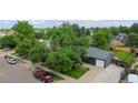 An aerial view of a home with a lush green yard and mature trees on a lovely street with other homes at 5170 Deephaven Ct, Denver, CO 80239