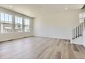 Bright, open living room with hardwood floors, large windows, and plenty of natural light at 683 N Deer Park St, Watkins, CO 80137