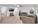 Cozy living room features comfortable seating, a ceiling fan, and bright windows at 23317 E Saratoga Cir, Aurora, CO 80016