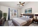 A large primary bedroom with a comfortable queen-sized bed, a ceiling fan, and an art piece at 4334 Lisbon St, Denver, CO 80249