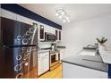 Modern kitchen features stainless steel appliances, white cabinetry, and sleek countertops at 14231 E Dickinson Dr # E, Aurora, CO 80014