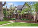 Lovely Tudor-style house featuring brickwork, lush greenery, and a well-maintained yard at 536 N Williams St, Denver, CO 80218