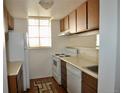 Efficient kitchen with white appliances, ample cabinet space, and a window for natural light at 12512 E Cornell Ave # 101, Aurora, CO 80014