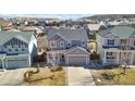 Aerial view of a gray two-story home surrounded by a residential neighborhood at 3323 Starry Night Loop, Castle Rock, CO 80109