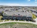 An elevated view of a neighborhood showcasing a row of modern townhouses with well-kept lawns and sidewalks at 22725 E Ottawa Pl, Aurora, CO 80016