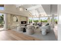 Bright living room with a stone fireplace, high ceilings, and a wall of windows at 4 Greenridge Rd, Greenwood Village, CO 80111