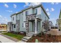 Charming townhome showcasing a stone-accented entrance, neat landscaping, and a sidewalk at 14109 Deertrack Ln, Parker, CO 80134