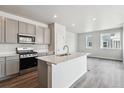 Modern kitchen with quartz countertop island, stainless appliances, and hardwood floors at 14109 Deertrack Ln, Parker, CO 80134