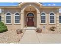 Inviting front door with an arched entryway, decorative windows, and security system at 38087 E 147Th Pl, Keenesburg, CO 80643