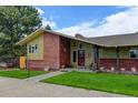 Brick and wood ranch home with covered entryway at 14121 Countryhills Dr, Brighton, CO 80601