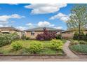Charming brick home with well-maintained landscaping, including green bushes and a vibrant red tree at 3620 Fairfax St, Denver, CO 80207