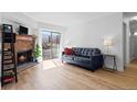 Bright living room featuring hardwood floors, fireplace, and sliding glass doors to the balcony at 14206 E 1St Dr # B10, Aurora, CO 80011