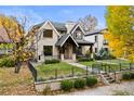 Charming brick home featuring a well-kept lawn, decorative fencing, and a welcoming covered entry at 2218 S Clayton St, Denver, CO 80210