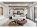 Bright living room featuring hardwood floors, beamed ceilings, and a seamless flow to the kitchen at 2218 S Clayton St, Denver, CO 80210