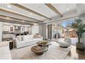 Bright living space featuring exposed beams, a modern sofa, and sliding glass doors to the backyard at 2218 S Clayton St, Denver, CO 80210