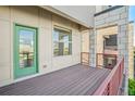 Private balcony view with a green door, red railings, and stone accents at 5668 Galena St, Denver, CO 80238