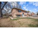 Side view of a two-story home with mature trees and a well-maintained lawn and a partial fence at 1529 Ashcroft Dr, Longmont, CO 80501